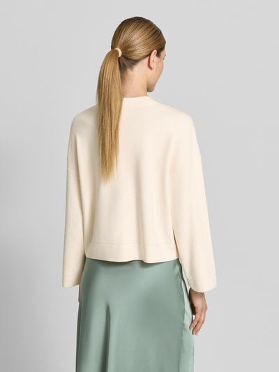 Frauenmodel trägt Strickjacke aus Viskose-Mix mit V-Ausschnitt von comma in offwhite, Relaxed Fit, glatte Textur, Rückansicht, Ganzkörperansicht.