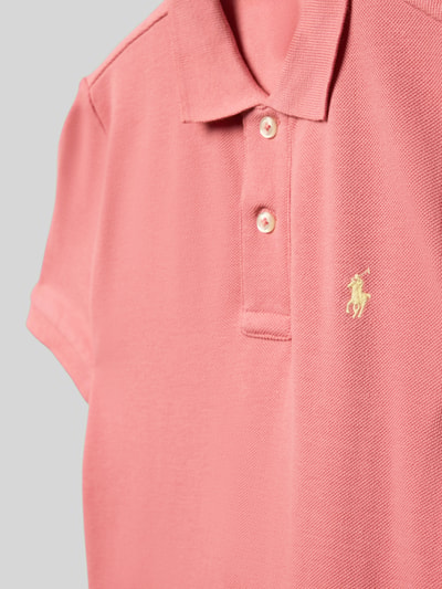 Mädchen trägt Regular Fit Poloshirt aus reiner Baumwolle von Polo Ralph Lauren Kids in Rosa, Piqué-Struktur, Logo-Stitching, Nahaufnahme Oberkörper.