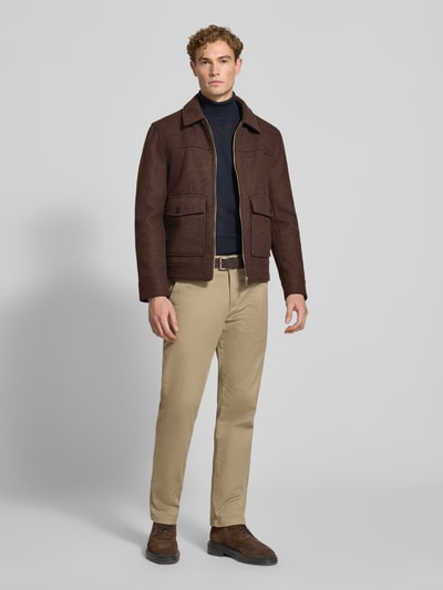 Männermodel trägt Regular Fit Jacke mit Viskose-Anteil von MCNEAL in Braun mit Umlegekragen und aufgesetzten Taschen, Ganzkörperansicht von vorne. Material-Mix, Logo-Patch, Reißverschluss, Rückenlänge 65 cm, Schulterbreite 45 cm, Brustweite 50 cm, Ärmellänge 68 cm.