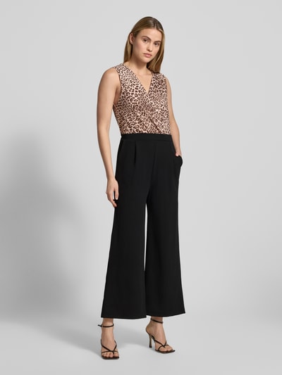 Frauenmodel trägt Jumpsuit mit V-Ausschnitt Modell 'Mi44rinanaa' von ZABAIONE im Cropped-Look, Material-Mix mit Stretch-Anteil, Eingrifftaschen, Ganzkörperansicht von vorne. Rückenlänge 23 cm, Brustweite 40 cm, Gesamtlänge 126 cm, Innenbeinlänge 65 cm, geeignet für Damen.