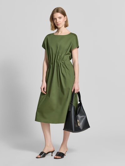 Frauenmodel trägt Midikleid mit Rundhalsausschnitt und Drapierungen von Christian Berg Woman Selection in Olivgrün, Baumwoll-Mix mit Stretch-Anteil, taillierter Schnitt, Ganzkörperansicht von vorne.
