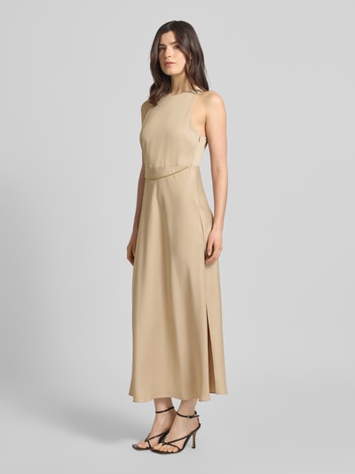 Vrouwenmodel draagt Maxikleid met Ketten-Detail van ARMANI EXCHANGE in beige satijn, getailleerd model, ronde hals, Ganzkörperansicht van voren. Ruglengte maat 36: 134 cm, borstwijdte maat 36: 38 cm.