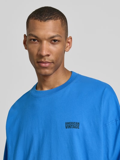 Männermodel trägt Longsleeve mit Logo-Print Modell 'GIXY' von American Vintage in Blau, aus Reine Baumwolle, Loose-Fit, Nahaufnahme Oberkörper.