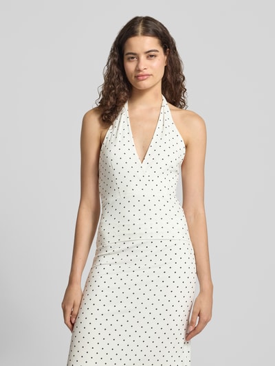 Frauenmodel trägt Slim Fit Top mit Neckholder von Gina Tricot in Weiß mit schwarzen Punkten, Elastischer-Material-Mix, V-Ausschnitt, Rückenlänge bei Größe S: 58 cm, Ganzkörperansicht von vorne.