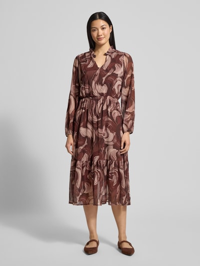 Frauenmodel trägt Midikleid mit V-Ausschnitt Modell 'Za44raa' von ZABAIONE, A-Linie, Stufen-Look, florale Muster, Ganzkörperansicht von vorne.