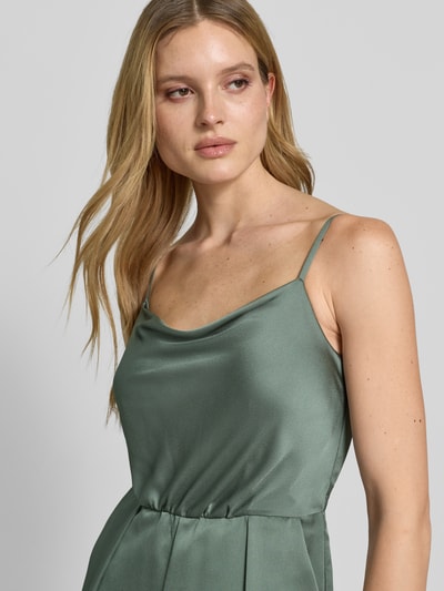 Kobiece model prezentuje Jumpsuit aus Satin mit Wasserfall-Ausschnitt od Jake*s Cocktail, zielony satynowy materiał, cienkie ramiączka, krój regular fit, długość całkowita 114 cm w rozmiarze 36, szerokość w rozmiarze 36: 28 cm, długość nogawki 56 cm, połyskliwa tekstura, zbliżenie na górną część ciała, ujęcie z przodu.