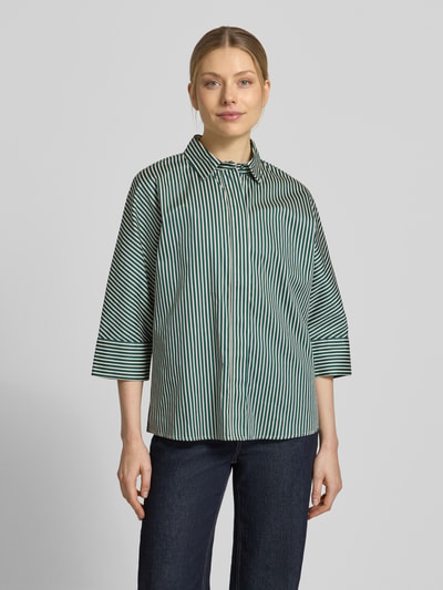 Frauenmodel trägt Regular Fit Hemdbluse mit durchgängiger Knopfleiste von Christian Berg Woman, Baumwolle, grün-weiß gestreift, Halbarm, Ganzkörperansicht von vorne.