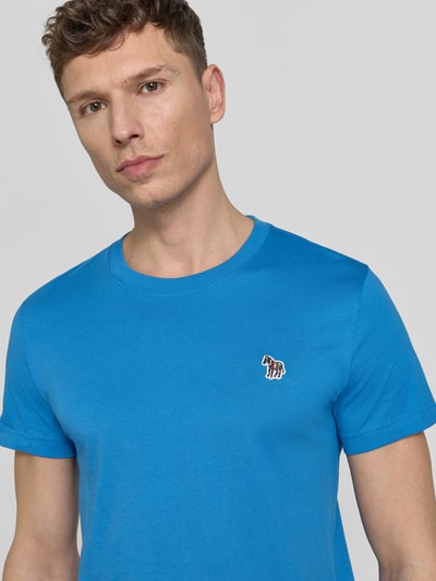 Männermodel trägt Slim Fit T-Shirt mit Rundhalsausschnitt von PAUL SMITH aus reiner Baumwolle, Stitching, kräftiges Blau, Nahaufnahme Oberkörper.