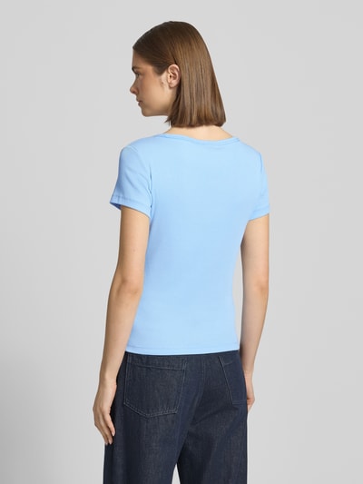 Vrouwenmodel draagt Slim Fit T-shirt uit katoenmix van Tommy Jeans, look: effen kleuren, logostitching, ronde hals, korte mouw, jersey materiaal, katoenmix, geheellichaamsaanzicht achteraan.