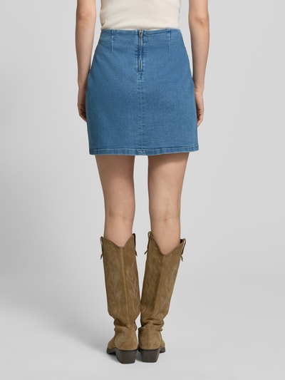 Frauenmodel trägt eng anliegenden Jeansrock aus Baumwoll-Mix Modell 'NELLY' von Vero Moda in Denim-Optik, Mini-Länge, Regular-Fit, Ganzkörperansicht Rückansicht