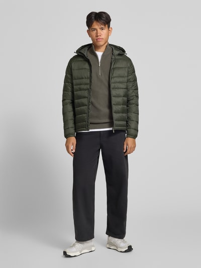 Männermodel trägt Regular Fit Pullover aus reiner Baumwolle Modell 'TONY' von ONLY & SONS in Olivgrün, Ganzkörperansicht von vorne.