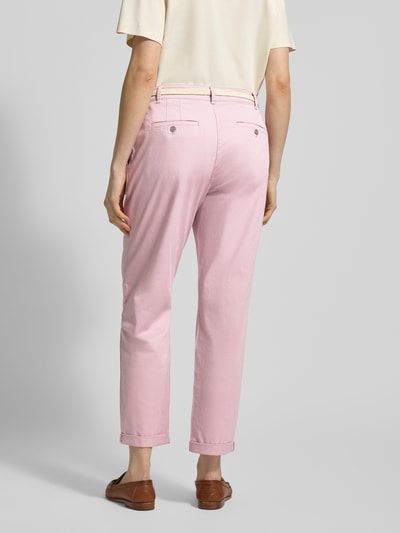 Frauenmodel trägt Casual Fit Chino mit Baumwoll-Anteil von Christian Berg Woman in Rosa, mit Gürtel, Gesäßtaschen, verkürzt, Ganzkörperansicht Rückansicht.