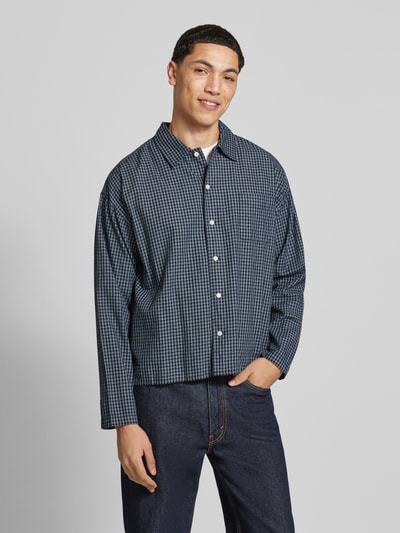 Mannenmodel draagt Regular Fit Freizeithemd aus Baumwolle Modell 'AUSTIN' van Jack & Jones met ruitpatroon in blauw en wit, knoopsluiting, borstzak, kentkraag, comfortabele pasvorm, pure katoen, vooraanzicht bovenlichaam