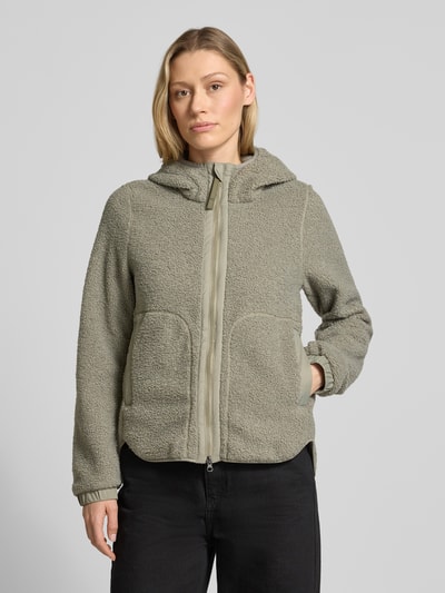 Frauenmodel trägt Regular Fit Jacke mit Kunstfellbesatz von camel active in Beige mit Stehkragen, Kapuze, Zweiwege-Reißverschluss, Eingrifftaschen, elastischen Ärmelabschlüssen; Rückenlänge 64 cm, Schulterbreite 38 cm, Brustweite 46 cm, Ärmellänge 62 cm; Ganzkörperansicht von vorne.
