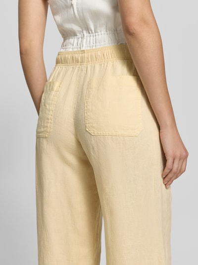 Frauenmodel trägt Leinenhose mit elastischem Bund Modell 'Mileni resort' von OPUS, Cremefarbe, Gesäßtaschen, Struktur, Ganzkörperansicht Rückansicht, Damen Leinenhose, Reines Leinen, Wide-Leg-Fit, Innenbeinlänge 80 cm, Bundweite 38 cm bei Größe 36.