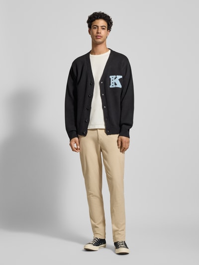Männermodel trägt Slim Fit Hose mit Gesäßtaschen Modell 'MARCO' van Jack & Jones in beige, katoen-elastaanmix, Ganzkörperansicht von vorne. Bundwijdte 42 cm, binnenbeenlengte 78 cm.