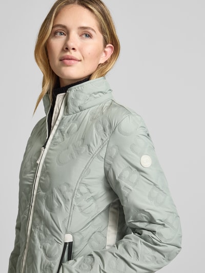 Vrouwenmodel draagt Jacke mit Stehkragen und Reißverschlusstaschen van Gil Bret in lichtgrijs, getailleerde fit, capuchon met tunnelkoord, ritszakken, katoenen textuur, weatherprotection, detailopname bovenlichaam.