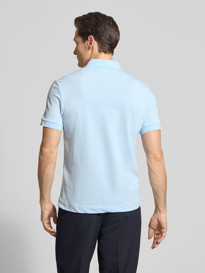 Męski model nosi Regular Fit Poloshirt aus Baumwoll-Mix von Lacoste, efekt: jednolity kolor, krój regular fit, wyhaftowane logo, kołnierzyk polo, rękaw: krótki rękaw, zakończenie: rozcięcia po bokach, wykończenie materiału: pika, mieszanka bawełny, całkowity widok od tyłu.