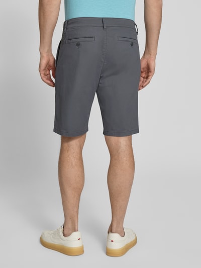 Männermodel trägt Regular Fit Bermudas aus Baumwoll-Mix Modell 'PHOENIX' von s.Oliver RED LABEL, efekt: jednolity kolor, krój regular fit, długość: krój krótki, 5 kieszeni, szlufki na pasek, zapięcie na guzik i zamek błyskawiczny, wykończenie materiału: splot twill, materiał: mieszanka bawełny, Ganzkörperansicht Rückansicht.