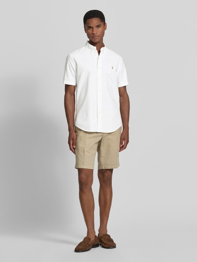 Mannenmodel draagt Regular Fit vrijetijdsoverhemd van puur katoen van Polo Ralph Lauren in wit, vooraanzicht, volledige lichaamsopname.