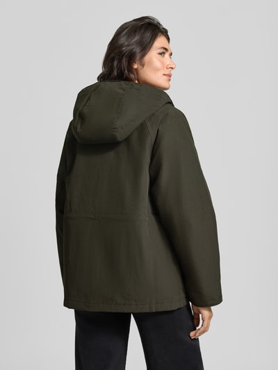 Frauenmodel trägt Loose Fit Funktionsjacke mit Kapuze Modell 'HESTER WATERPROOF' von Barbour in Dunkelgrün, Ganzkörperansicht Rückansicht. Damen Funktionsjacke von Barbour.