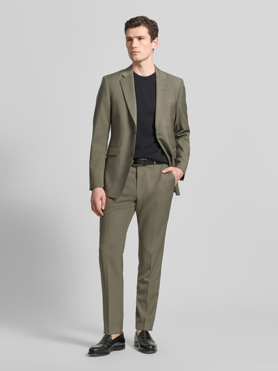 Männermodel trägt Regular Fit Blazer mit Logo-Patch Modell 'Justin' van Tiger Of Sweden in olijfgroen, puur katoen, borstzak, klepzakken, reverskraag, 2-knoopsluiting, ruglengte 79 cm, schouderbreedte 38 cm, mouwlengte 66 cm, heren blazer, ganzkörperansicht van voren.