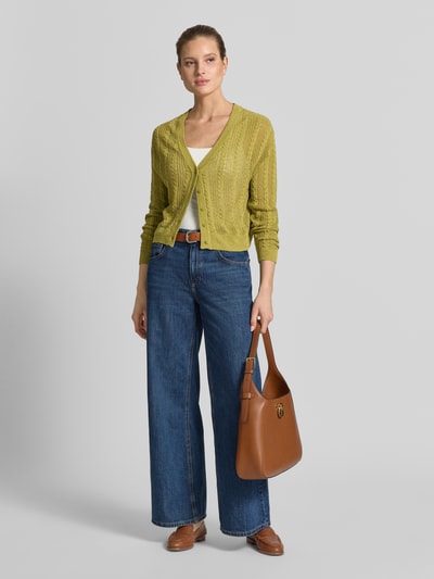 Frauenmodel trägt Strickjacke mit V-Ausschnitt Modell 'ROSI' von Mango in Gelbgrün, Baumwoll-Mix, Regular Fit, Knopfleiste, Ganzkörperansicht von vorne.