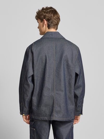 Männermodel trägt dunkelblaue Jeansjacke mit aufgesetzten Taschen Modell 'ADEN' von Carhartt Work In Progress, Relaxed Fit, Rückansicht