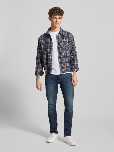 Męski model nosi Jeansy z 5 kieszeniami od LEVI'S®, mieszanka bawełny i elastanu, krój slim fit, kolor niebieski, szerokość w rozmiarze 32/32: 42 cm, długość wewnętrzna nogawki: 79 cm, zapięcie na guzik i zamek błyskawiczny, pełny widok z przodu