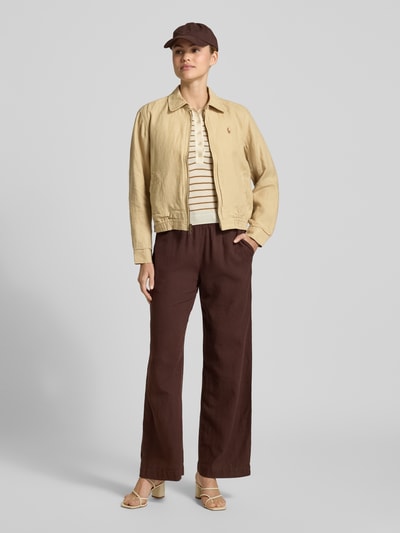 Vrouwenmodel draagt Regular Fit Jacke aus reinem Leinen van Polo Ralph Lauren in effen kleuren, platte kraag, tweewegritssluiting, gestikt logo, lange mouw met manchet, elastische rompzoom, steekzakken, materiaal: linnen. Ganzkörperansicht von voren.