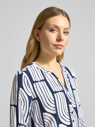 Frauenmodel trägt Wellen-Print Schlupfbluse aus Viskose von Christian Berg Woman, Regular-Fit, V-Ausschnitt, Nahaufnahme Oberkörper.
