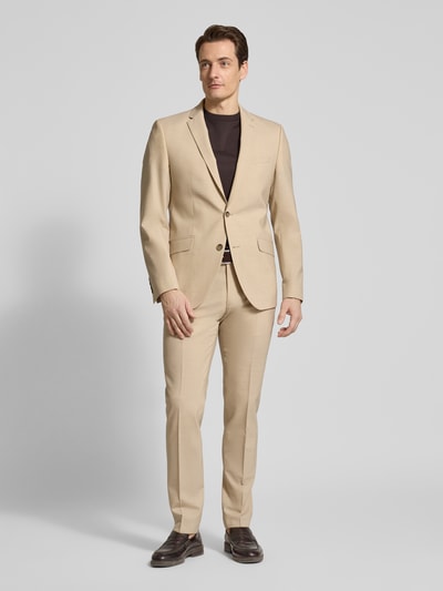 Männermodel trägt Slim Fit 2-Knopf-Sakko mit Pattentaschen Modell 'Allen' von DIGEL aus reiner Viskose, sandfarben, Ganzkörperansicht von vorne.