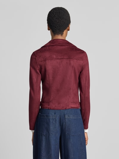 Frauenmodel trägt Regular Fit Kunstlederjacke mit Riegeln am Rumpf Modell 'JOSE' von VERO MODA in Dunkelrot, matte Textur, Ganzkörperansicht Rückansicht. Damen Leder- / Kunstlederjacke.