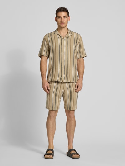 Männermodel trägt Regular Fit Freizeithemd mit Kentkragen van MCNEAL in beige gestreept katoen, knoopsluiting, voorkant volledige lichaamsweergave.
