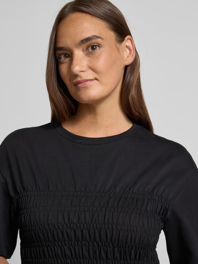 Frauenmodel trägt T-Shirt mit Smok-Details und Rundhalsausschnitt von Jake*s Casual in Schwarz, reine Baumwolle, Slim Fit, Nahaufnahme Oberkörper.