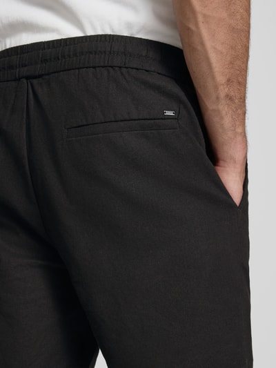 Männermodel trägt Regular Fit Bermudas aus Baumwoll-Leinen-Mix Modell 'LINUS' von Only & Sons, unifarben, Nahaufnahme Rückansicht.