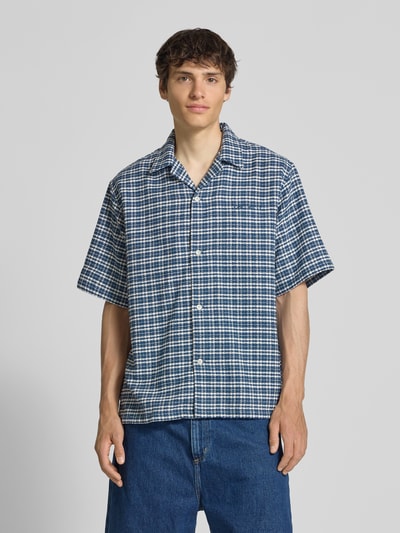 Männermodel trägt Regular Fit Freizeithemd aus reiner Baumwolle von Carhartt Work In Progress, Strukturmuster, Halbarm, Ganzkörperansicht von vorne.