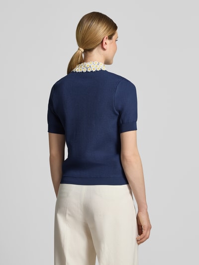 Frauenmodel trägt Regular Fit Poloshirt aus Viskose-Mix Modell 'JAMBER' von Essentiel Antwerp in Dunkelblau mit cremefarbener Hose, Ganzkörperansicht Rückansicht.