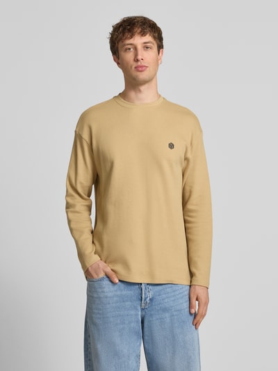 Männermodel trägt Longsleeve aus Baumwolle Modell 'FILLIP' von Blend in Beige mit Rundhalsausschnitt, Gerader-Schnitt, Label-Detail, Ganzkörperansicht von vorne. Herren Longsleeve, Reine Baumwolle, Rückenlänge bei Größe M: 70 cm.