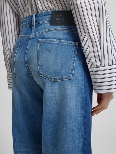 Frauenmodel trägt Wide Fit Jeans in verkürzter Passform Modell 'Oria' von Cambio, elastischer Baumwoll-Mix, blaue Waschung, 5-Pocket-Design, Nahaufnahme Rückansicht.