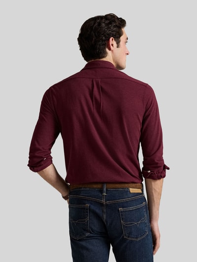 Męski model nosi koszulę casualową Regular Fit Freizeithemd aus reiner Baumwolle von Polo Ralph Lauren w kolorze bordowym, widok całej sylwetki od tyłu.