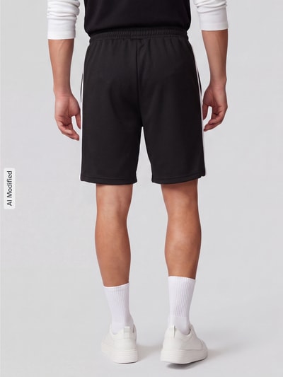 Männermodel trägt Relaxed Fit Sweatshorts mit Baumwoll-Anteil von PUMA Performance in Schwarz, elastische Struktur, Ganzkörperansicht Rückansicht, KI-modifiziertes Bild