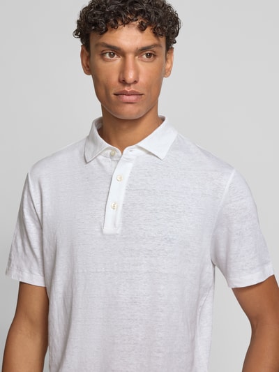 Männermodel trägt weißes Slim Fit Poloshirt aus Leinen-Elasthan-Mix von OLYMP Level Five, feine Textur, Nahaufnahme Oberkörper.