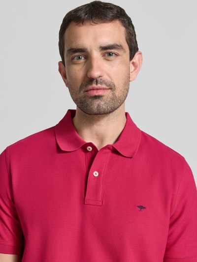 Männermodel trägt Regular Fit Poloshirt mit Label-Stitching von Fynch-Hatton in Pink, reine Baumwolle, Nahaufnahme Oberkörper.