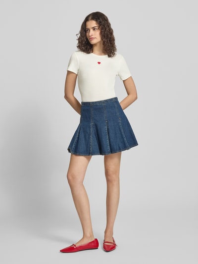Frauenmodel trägt Slim Fit T-Shirt mit Herz-Stickerei Modell 'ELVA JUNE' von Only in Unifarbe, Rippstruktur, Ganzkörperansicht von vorne.