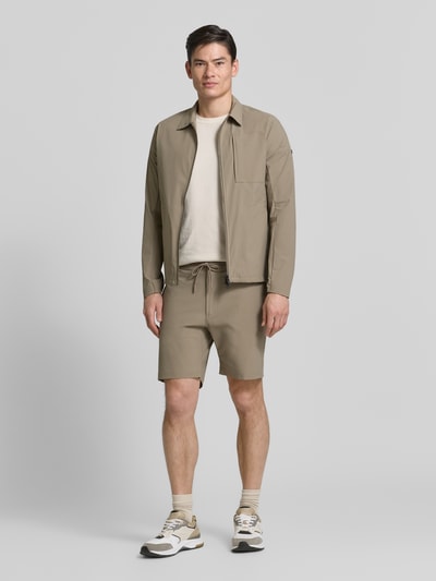 Männermodel trägt Regular Fit Jacke mit Umlegekragen Modell 'Motion' von SCANDINAVIAN EDITION in Beige, elastischer Material-Mix, Ganzkörperansicht von vorne.