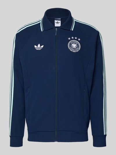 Produktfoto, Regular Fit Trainingsjacke mit Deutschland Logo von adidas Sportswear, Optik: Unifarben, Kontraststreifen, Reißverschluss, Label-Stitching, Stehkragen, Langarm, Ärmelabschluss gerippt, seitliche Eingrifftaschen