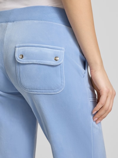Frauenmodel trägt Low Rise Sweatpants mit Eingrifftaschen Modell 'LAYLA' von Juicy Couture, hellblauer Material-Mix mit Stretch-Anteil, Detailaufnahme rückseitige Taschenpartie.