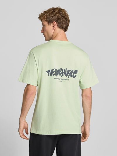 Männermodel trägt Relaxed Fit T-Shirt aus reiner Baumwolle mit Logo-Print von The North Face in lichtgroen, logoprint, ronde hals, ruglengte maat M 72 cm, Ganzkörperansicht Rückansicht.