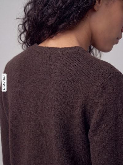 Frauenmodel trägt Regular Fit Strickjacke mit Woll-Anteil Modell 'MALOU' von PIECES, braune Farbe, weiche Textur, Nahaufnahme Rückansicht, KI-modifiziertes Bild.